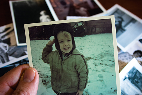 Hand holding old photograph of a kid