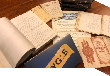 Genealogy documents and a laptop with an NYG&B logo