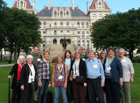 A group poses in front of a building in Albany, NY